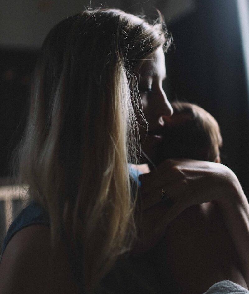 woman carrying baby in the dark