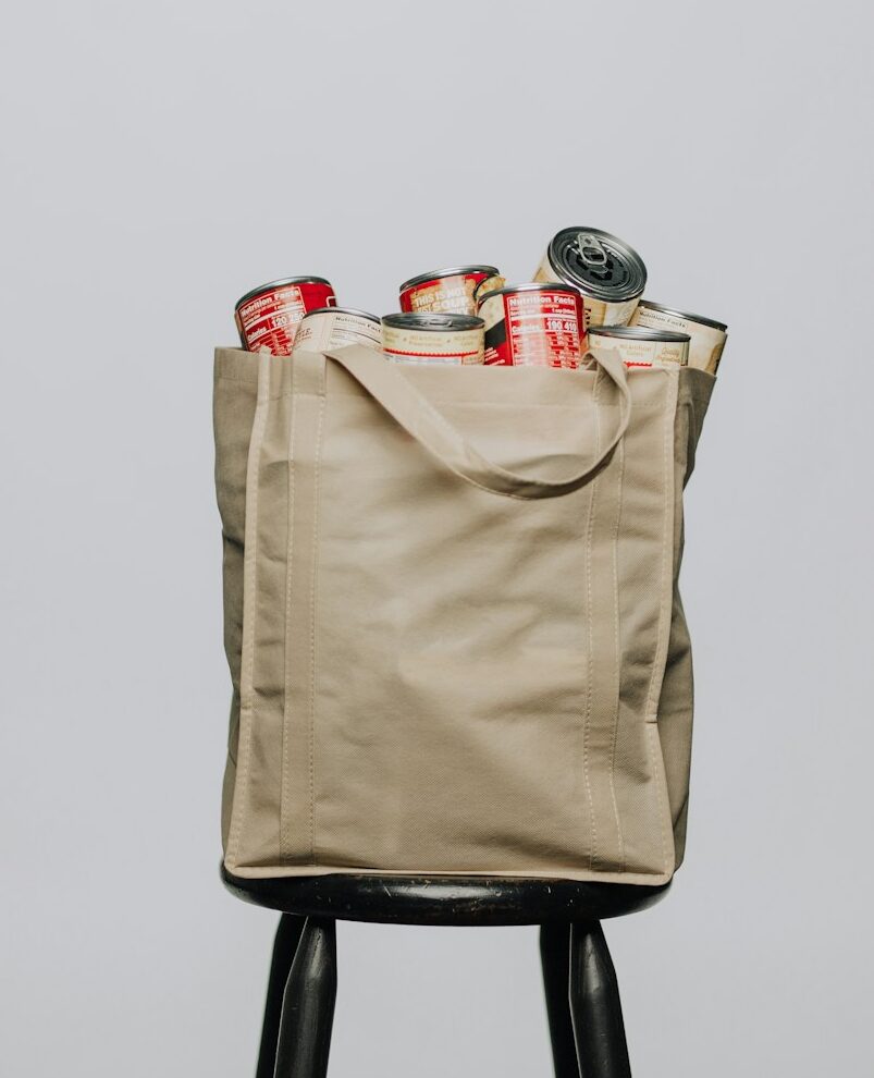 red labeled cans on white fabric handbag
